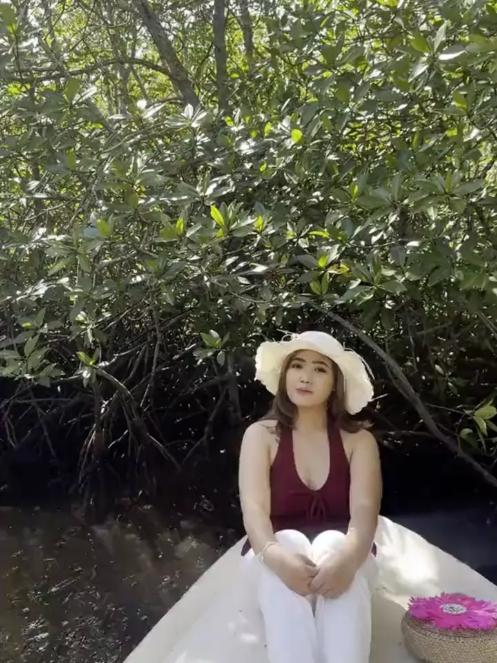 Potret di perahu di antara pohon mangrove.