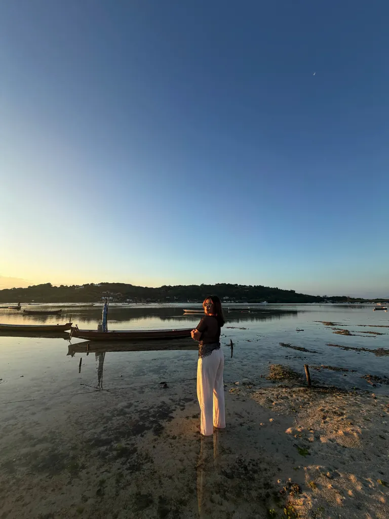 Berdiri di pantai saat matahari terbenam.